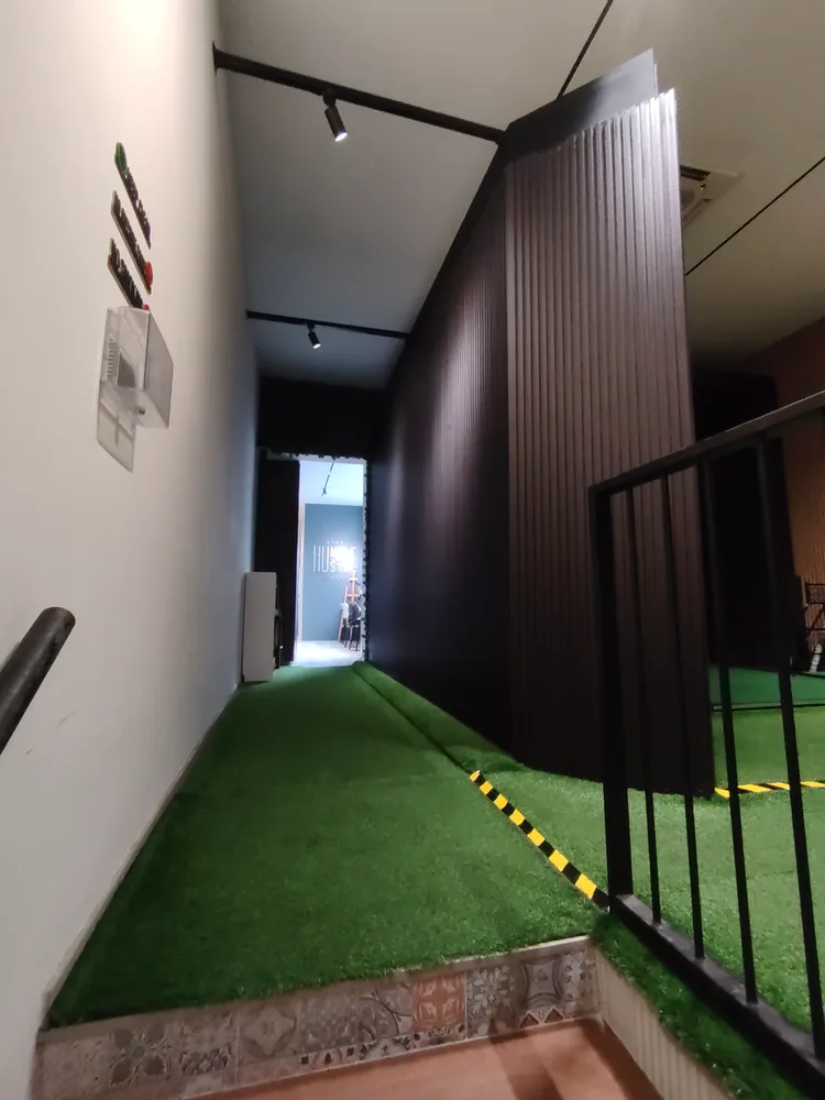 Turf walkway through AnyBirdie towards the Stay Humble Hustle Hard wall