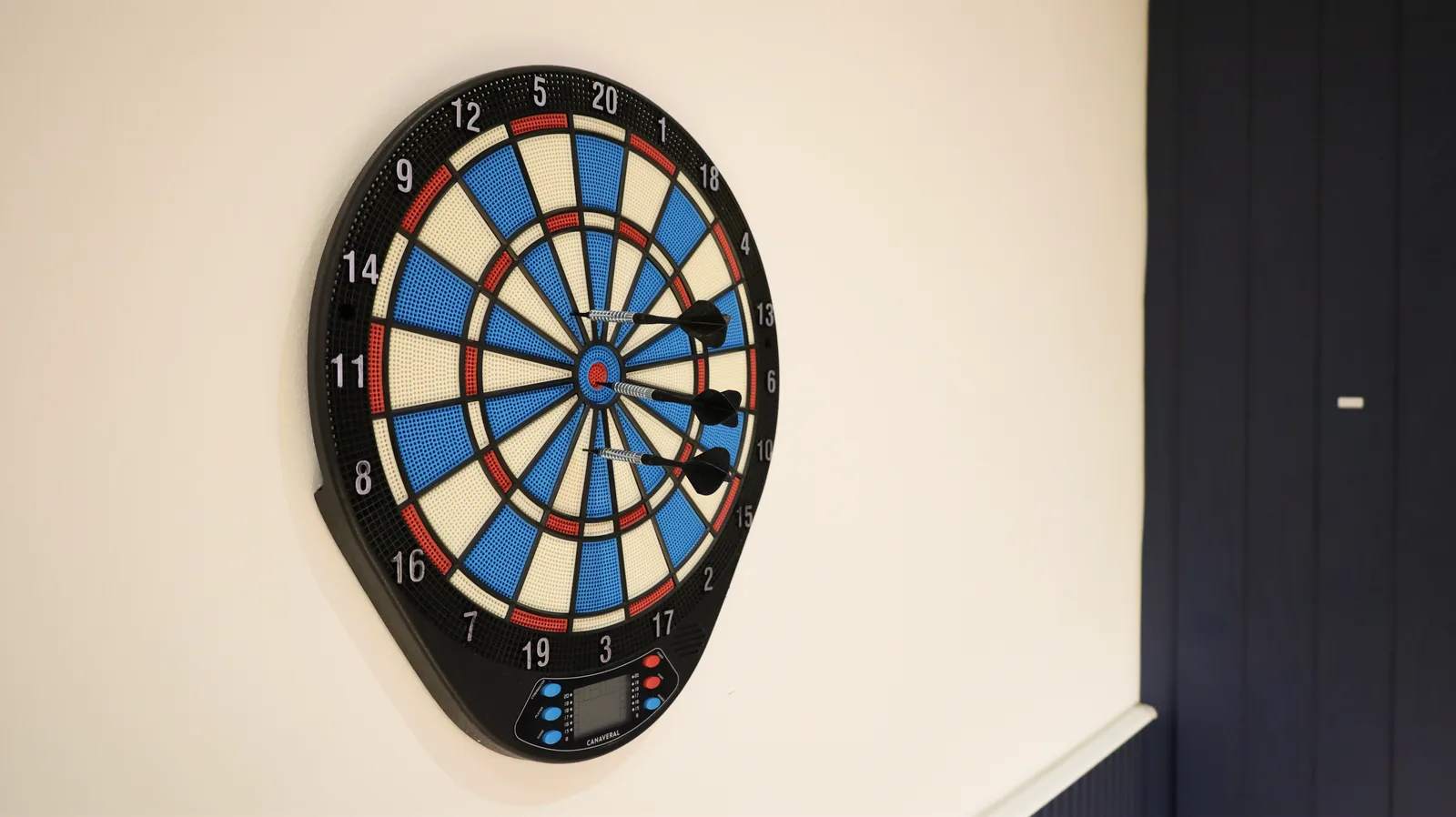 Electronic dartboard mounted on the wall at The Loft