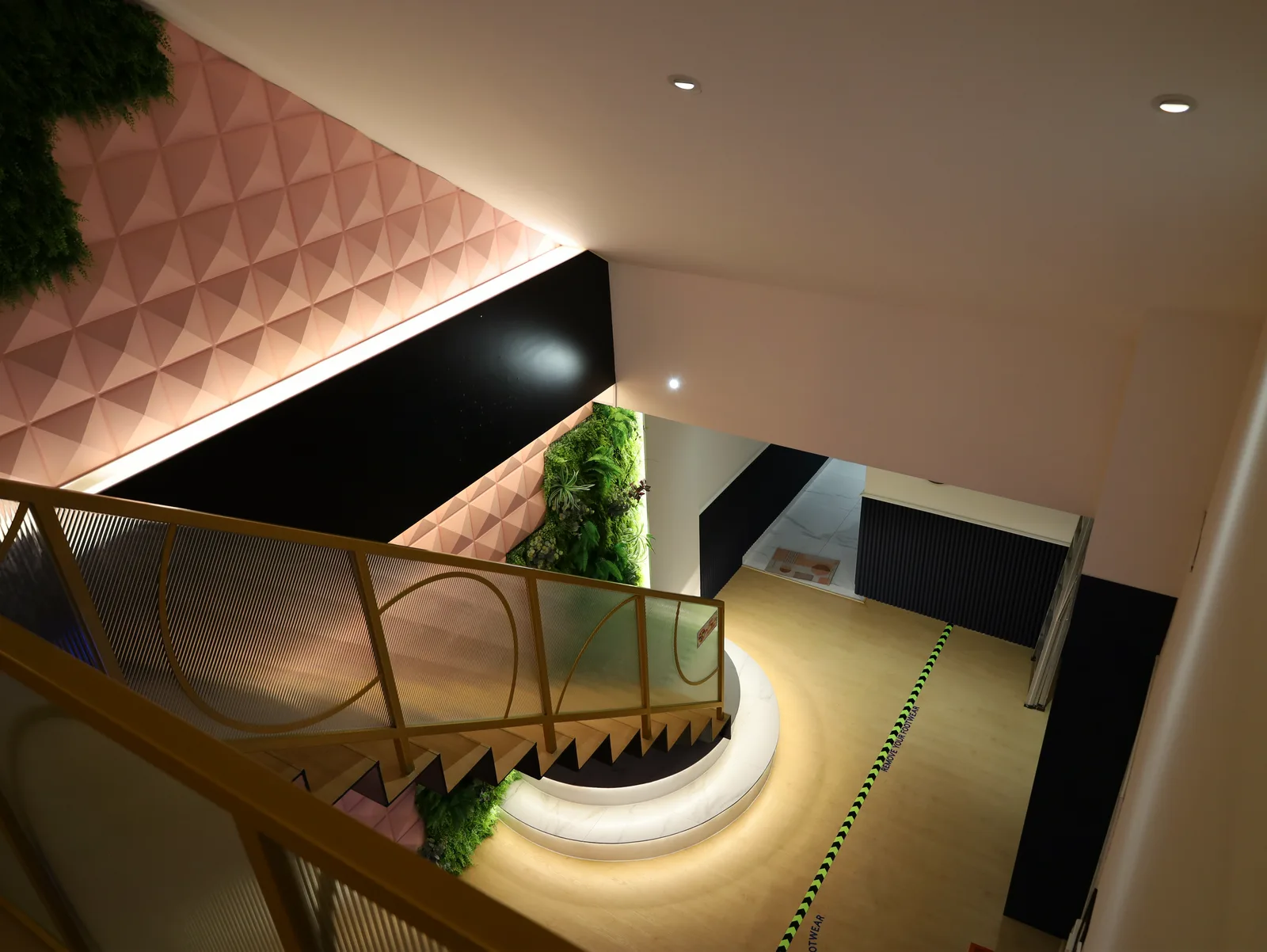 The Loft stairwell from the upper floor, with planted wall and curved landing