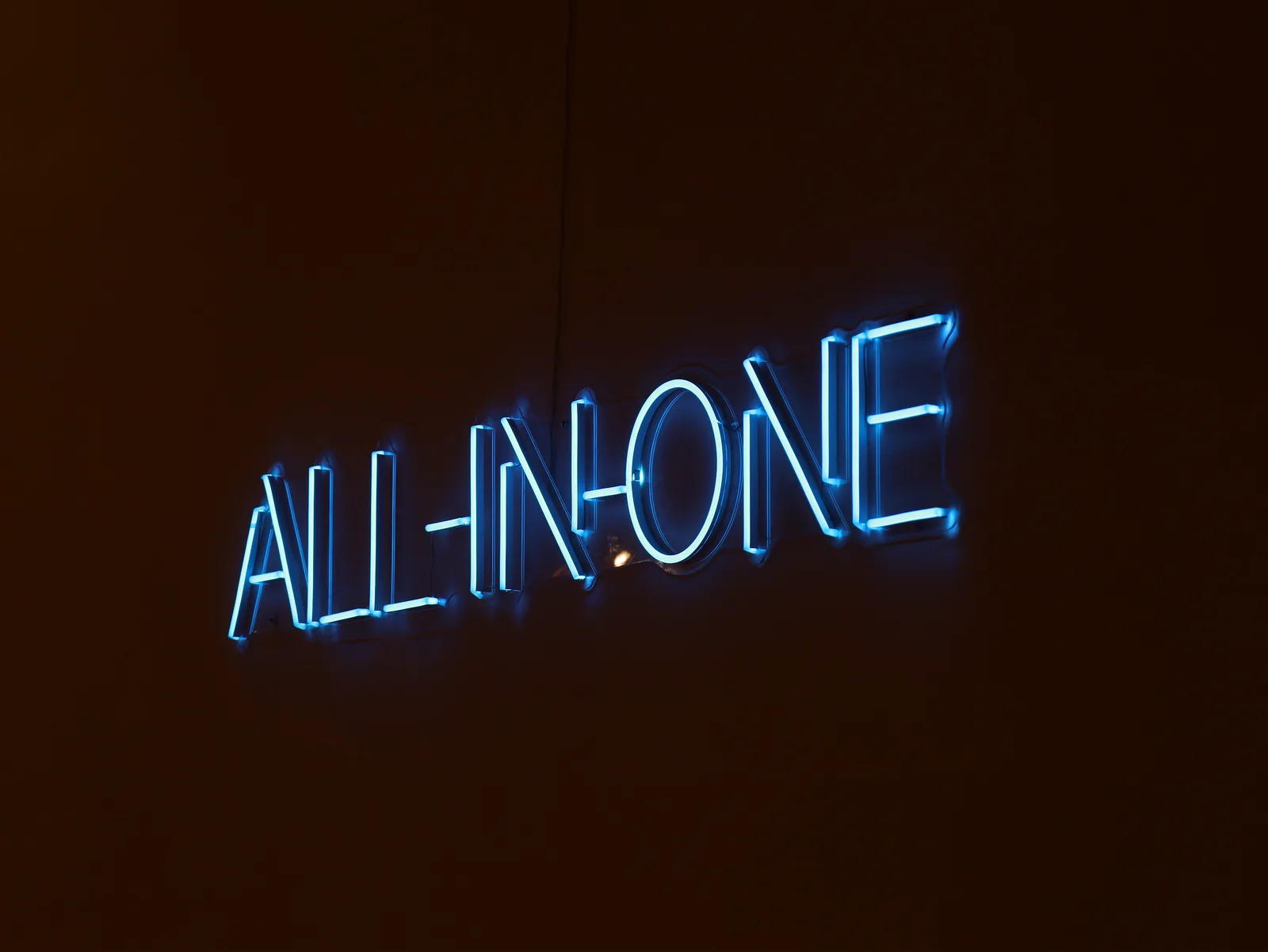 ALL-IN-ONE neon sign glowing on the wall at The Loft